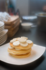 three pancakes with banana in white dish. vintage concept