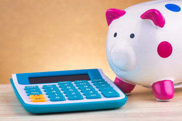 calculator and white piggy bank  for financial and saving concept over reverberation gradient background