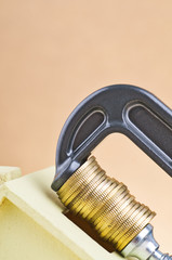 Low budget for home financing, coins squeezed tightly in a G-Clamp