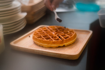 waffles with chocolate sauce on wooden plate. vintage concept