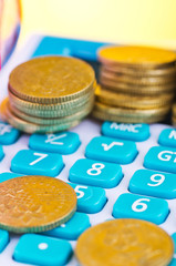 Stacking coins on calculator over beautiful reverberation gradient background for saving business investment concept