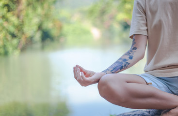 woman practices yoga and meditates in the lotus position, outdoor, lake in mountain