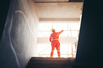 engineer with blueprint working on building site