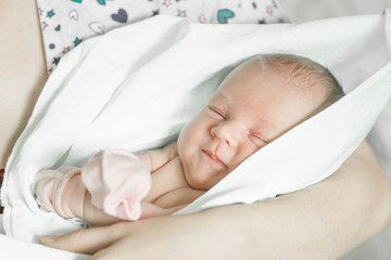 Sleeping newborn baby closeup portrait in mother's hands