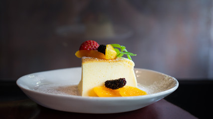 Japanese Cheese Cake with fruit on a white dish.