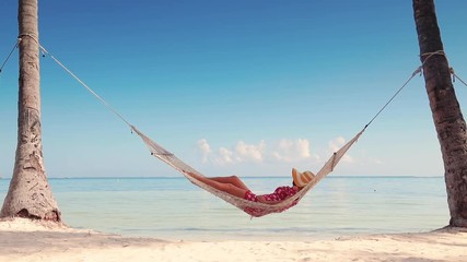Girl relaxing in a hammock on tropical island beach. Summer vacation in Punta Cana, Dominican Republic - Powered by Adobe