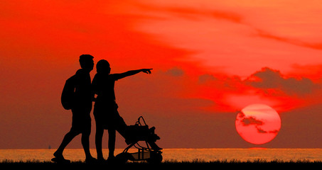 Fototapeta na wymiar silhouette happy family on the beach at sunrise time