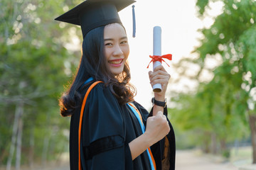 Female university graduate celebrates graduation ceremony receiving degree certificate happily with excitement.