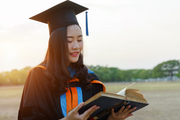 Female university graduate celebrates graduation ceremony receiving degree certificate happily with excitement.