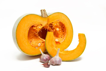 A group of one half and one slice of fresh pumpkinand garlic  isolated on a white background. Close-up.