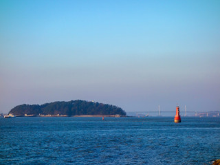 Incheon coastline, South Korea, under the background of sunset and blue sky, with ships sailing, city horizon.