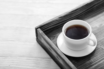 cup of coffee on tray on wooden table