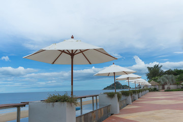 Summer day at the beach with white umbrellas.
