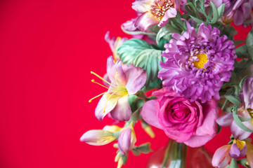 beautiful artificial flowers on red background. Art soft focus