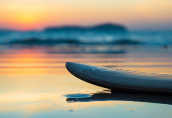 Fototapeta na wymiar surfboard on the beach in sea shore at sunset time