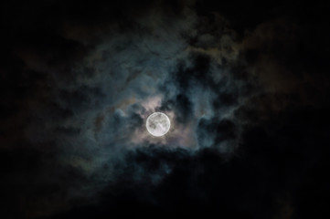 Picture of a full moon on a cloudy night.