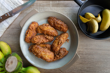 Deep fried banana in stone dish with banana on table.