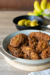 Deep fried banana in stone dish with banana on table.