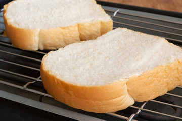 Slices bread on toaster.