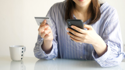 スマホとカードを見る女性