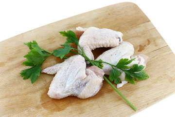 raw chicken wing on wooden board
