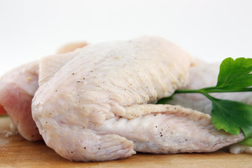 raw chicken wing on wooden board