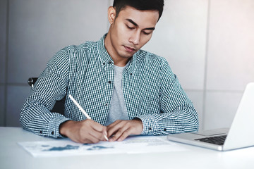Young Businessman Working on Computer Laptop in Office. Sitting on Desk, Man in Casual Wear