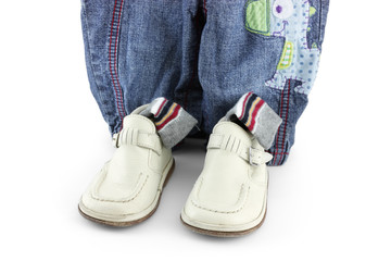 pair of baby boots and jeans on white background 