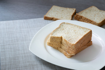 Whole Grain Bread in white dish on concrete table.