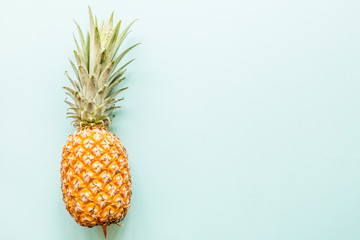 Fresh pineapple lying on blue background. Top view. Flat lay concept