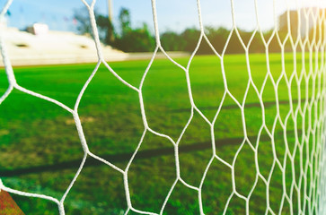 Soccer goal net with grass green, The nets of football goal with field grass, football net and blue sky.