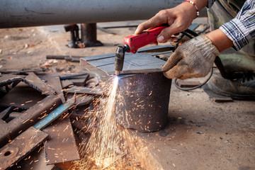 Hand of man / industrial worker use angle grinder to cut metal or steel