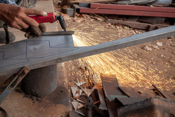 Hand of man / industrial worker use angle grinder to cut metal or steel