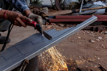 Hand of man / industrial worker use angle grinder to cut metal or steel