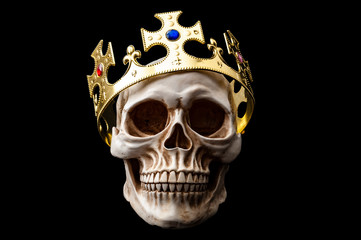 Happy Halloween, Monarchy and Dead King concept theme with a human skull wearing a shiny gold crown isolated on black background with high contrast and a clip path cut out