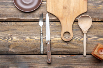 utensils with square candle and vintage cutlery on wooden background, top view 