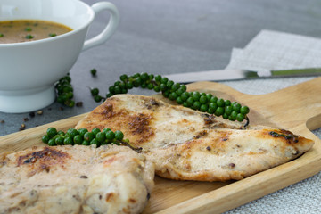 Fried chicken breast or chicken breast steak with black pepper in wooden dish on concrete table.