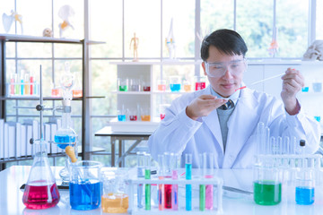 Scientist dropping red liquid to sample tray.