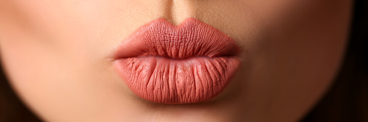 Beautiful female lips making kiss gesture flirting to camera