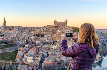 woman taking pictures with her mobile phone in Toledo - obrazy, fototapety, plakaty