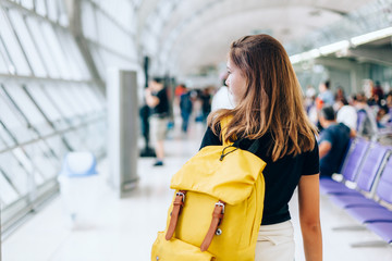 Teen girl waiting for international flight in airport departure terminal
