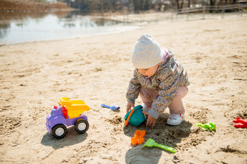 Family day in the park. Happy young couple with newborn baby. Mother carry baby in ergonomic baby carrier