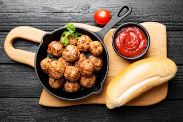 Meatballs served with tomato sauce in frying pan .