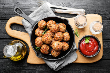 Meatballs served with tomato sauce in frying pan .