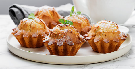 Fresh homemade delicious vanilla muffins with powdered sugar.