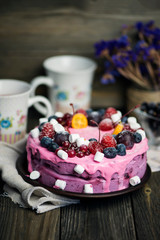 yogurt cake with fruit and marshmallows on a wooden background