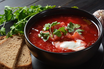 Traditional Ukrainian Russian borsch. Bowl of red beet root soup borsch with white cream on dark background. Beet Root delicious soup . Traditional Ukrainian food cuisine