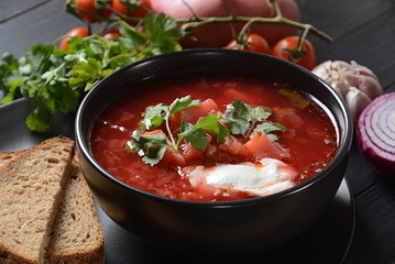 Traditional Ukrainian Russian borsch. Bowl of red beet root soup borsch with white cream on dark background. Beet Root delicious soup . Traditional Ukrainian food cuisine