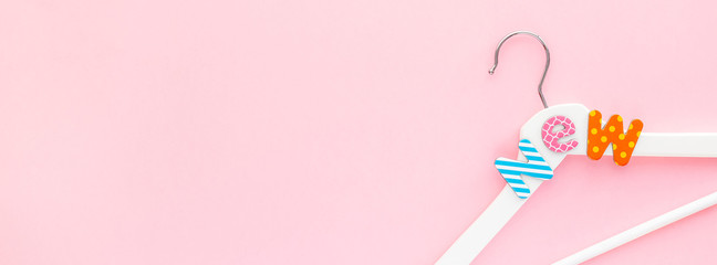 White hangers with sale text on pink background