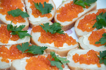 Sandwiches with caviar. Red caviar. Food on the holiday table. Snacks on a plate.